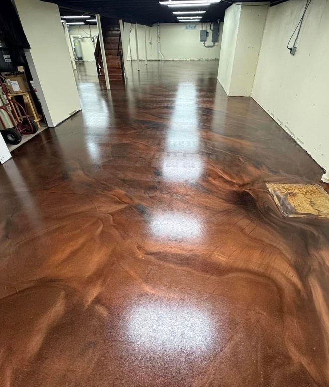 Copper and bronze metallic floor running the length of a commercial interior corridor with strip lighting reflected in the surface